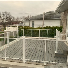 Une terrasse en bois dotée d'un garde-corps blanc offrant une vue dégagée sur les environs
