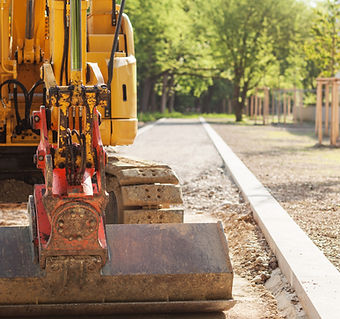 A yellow excavator on a sunny day sits on a construction site