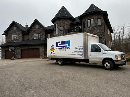 A plumbing company’s van is parked in front of the house