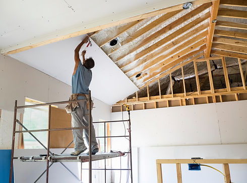 A man is engaged in ceiling work inside a home