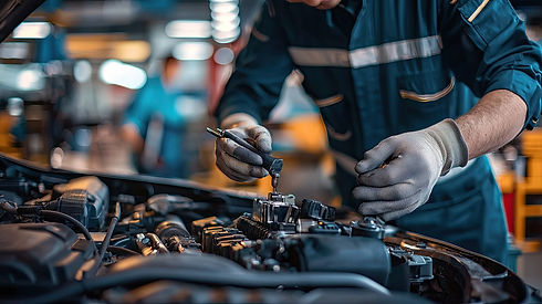 Mechanic in gloves focused on repairing a car engine in a well-lit garage