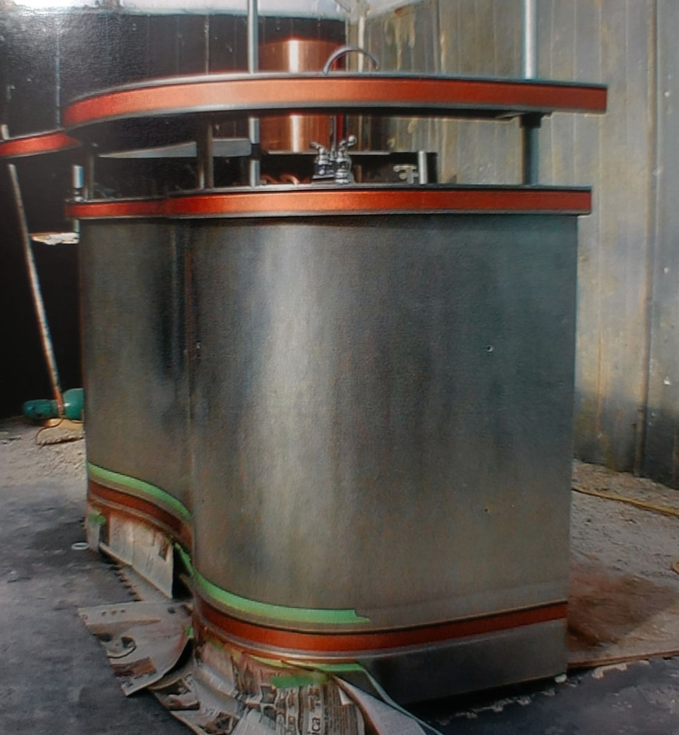 A metallic, rounded industrial structure with orange trim is in a workshop