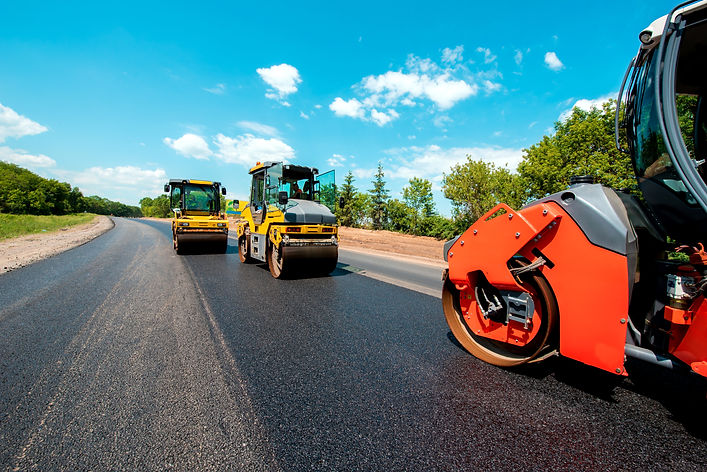 Industrial landscape with rollers that rolls a new asphalt in the roadway