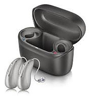 Open black charging case with two sleek, modern hearing aids beside it
