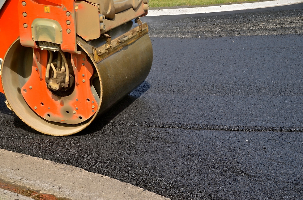 A heavy roller packs asphalt on a street resurfacing project