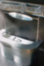 Curved chrome sink with a sleek design, featuring an overhead mirror
