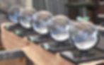 Six large glass balls arranged on a table