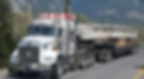 Heavy haul truck transporting bridge beam through mountain highway