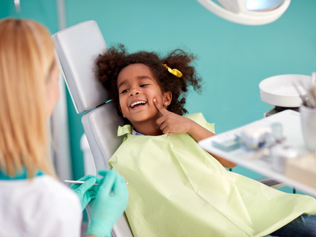 A smiling little girl is having fun at her dentist visit