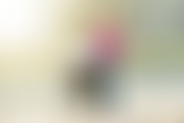 Rearview of man in a wheelchair and woman acting as a caregiver standing beside him looking out at a lake