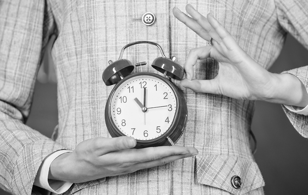 Close-up of person’s hands holding up clock emphasizing the concept of time