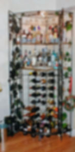 A corner bar stand with shelves of liquor bottles and hanging glasses