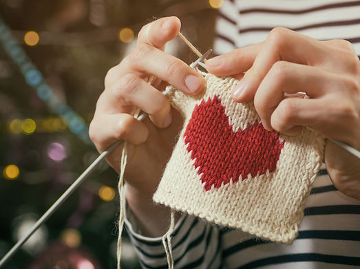 Close-up of hands knitting with white yarn
