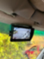 A rearview camera screen mounted inside a vehicle