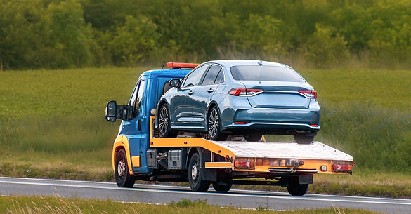 Une dépanneuse transporte une berline bleue sur son plateau