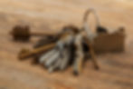 A set of various metal keys on a wood surface