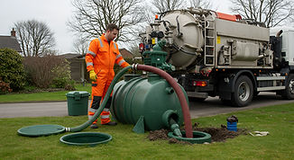Man in orange work suit operates septic pump