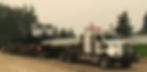 Heavy haul truck transporting tracked machinery on lowboy trailer