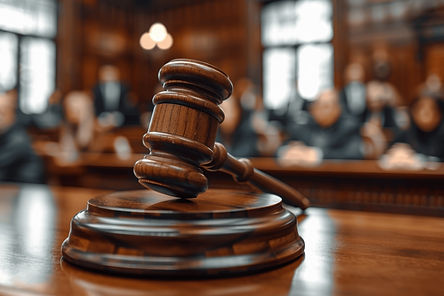 A judge's gavel rests on a wooden table in a courtroom