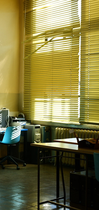 A room filled with multiple computers and a large window allowing natural light to enter