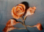 A copper metallic rose with detailed petals and leaves rests on a dark surface