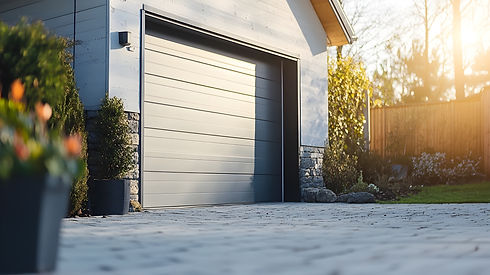 Modern garage door with sunlight shining on driveway