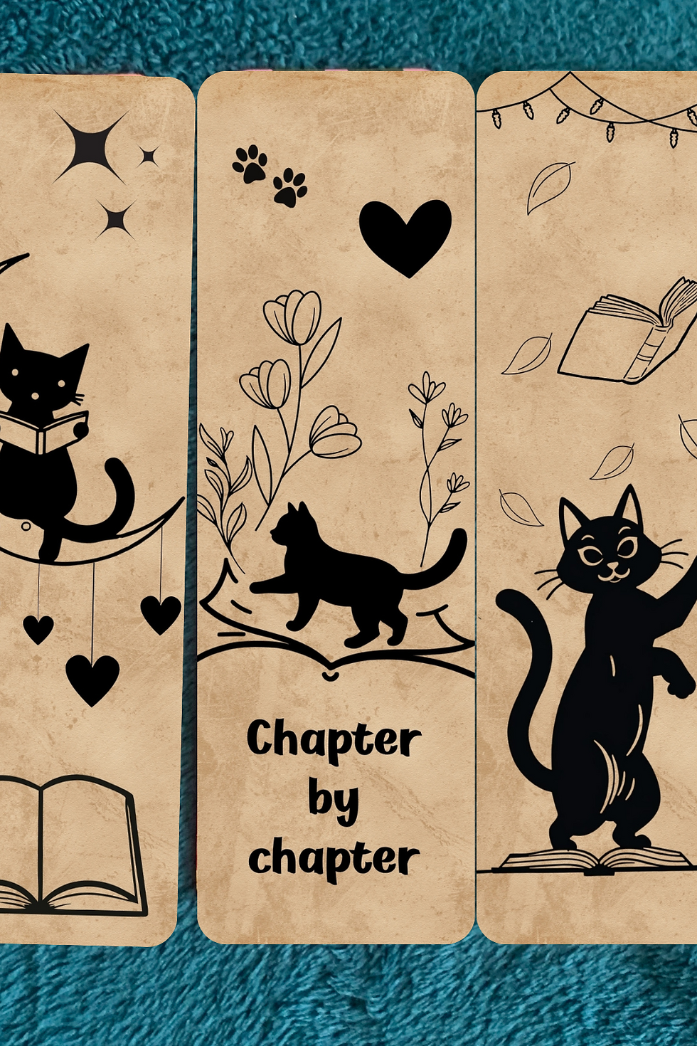 Silhouettes of cats, books, hearts, and flowers on textured bookmarks. Text "Chapter by chapter." Background is teal fabric.