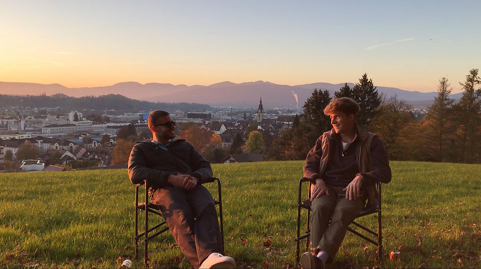 Sven Thalmann und Dario Wikihalter sitzen auf Stühlen in der Natur und unterhalten sich