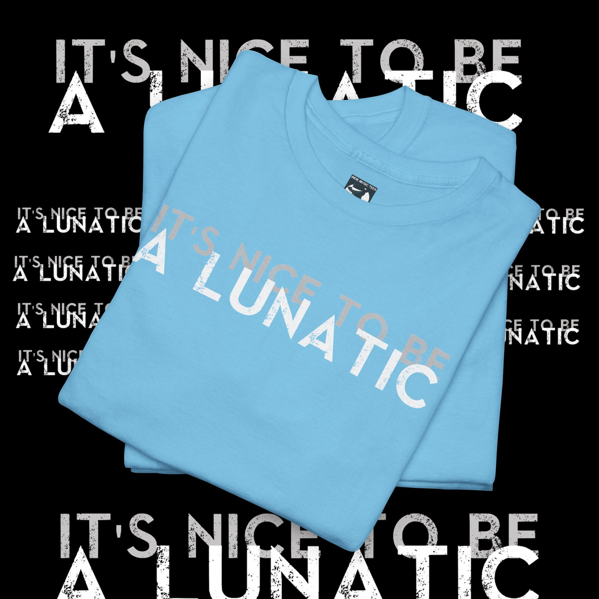 Light blue T-shirt reads "IT'S NICE TO BE A LUNATIC." indiemusictees