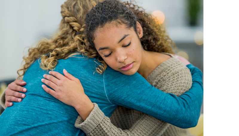 Teenager being emotionally supported with a hug