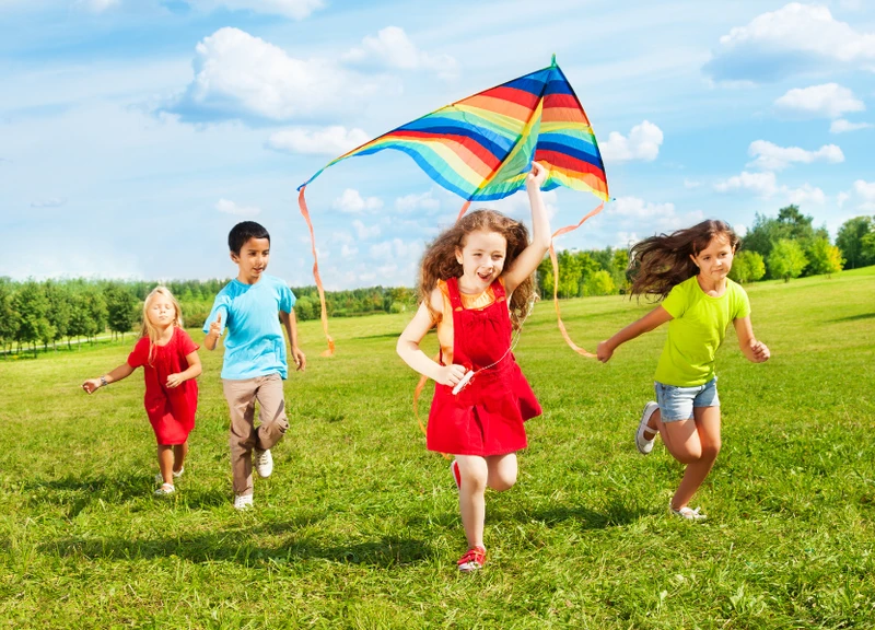 children running with a kite