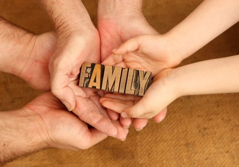 Family members holding the word family in their hands