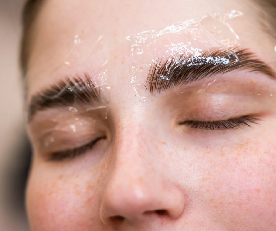 Eye-level view of brow lamination tools and products on a clean white surface