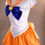 Küçük resim: Sailor Venus cosplay kostümü yan görünüm, turuncu anime cosplay eteği ve fiyonk detayları