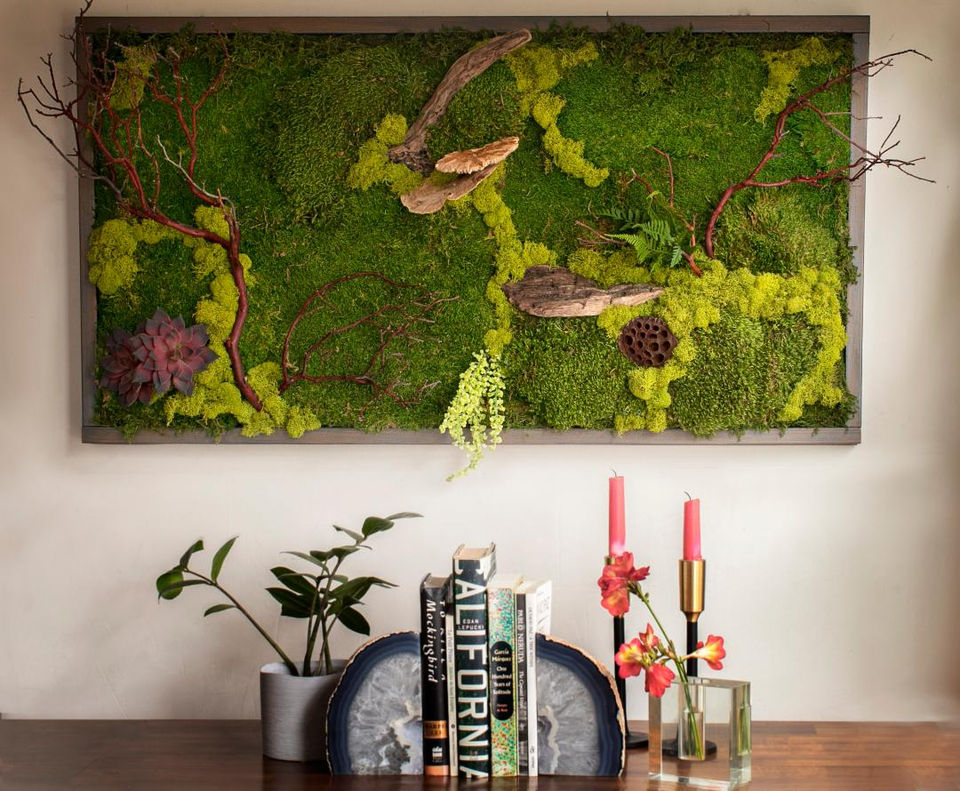 Custom decorative moss art with driftwood hanging in a home interior