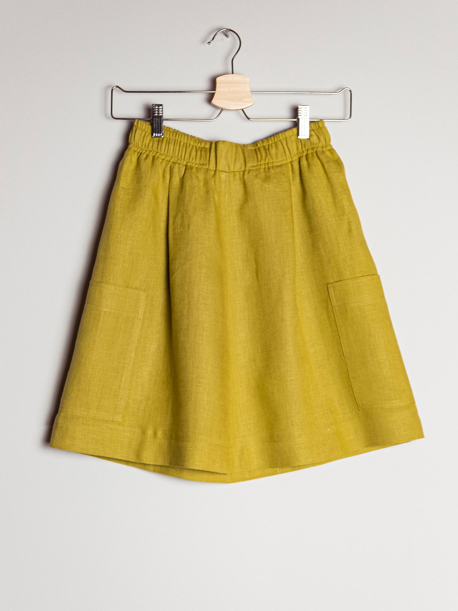 Elastik belli geniş yama cepli keten dizüstü etek arkadan görünüm askıda