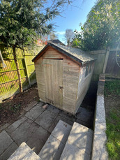 A garden with wooden fencing, patio steps down to an old wooden shed. This is before the garden office was built.