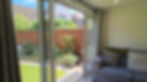Sofa in a Cosy Garden Room, patio doors are open looking out into a sunny garden.