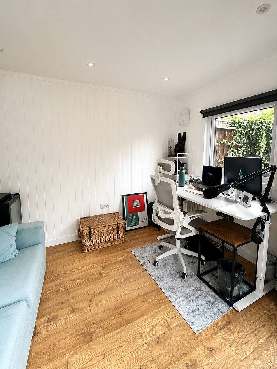 Finished garden office in Nottingham with desk, dual monitors, side window and light chestnut laminate flooring.