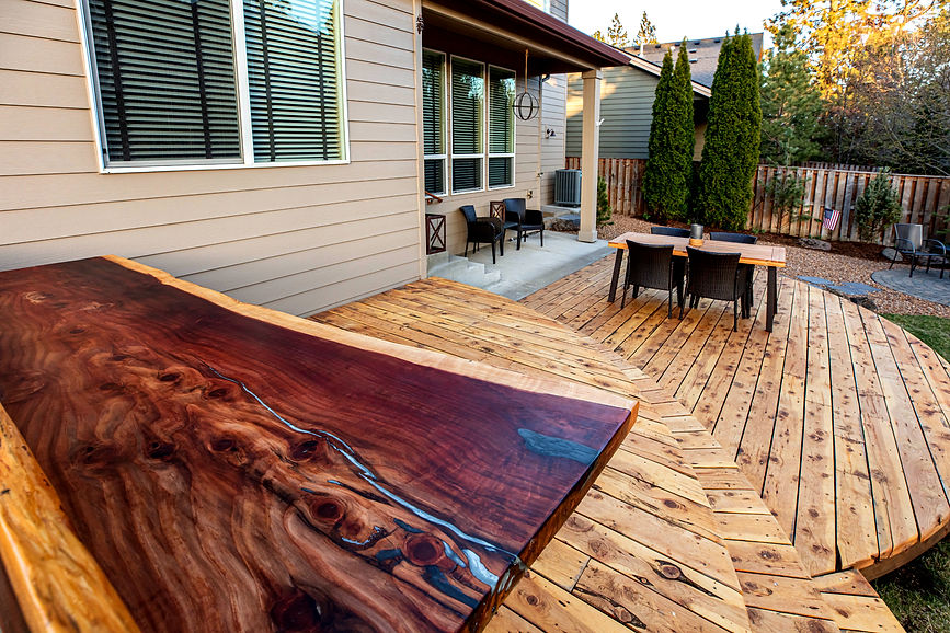 Wood details and rounded wood deck with patio furniture by a carpenter and ADU builder in Bend. 