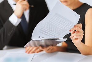 Two people reading through a report 