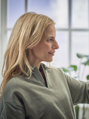 Frau bedient Heizungs-Thermostat; Installateur für Bad, Heizung, Wasser und Sanitär in Bad Vöslau: Pluy bietet Wärmepumpen, Heizungsmodernisierung und Reparaturen.