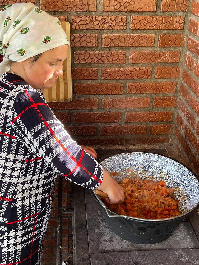 Woman with scarf stirring a stew