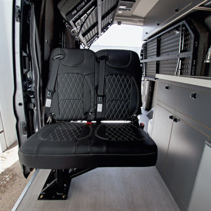 Optional fold-down seat for two in Ford Transit camper van, increasing seating capacity from 2 to 4 for family or group travel.