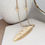 Thumbnail: Golden long leaf necklace with stars