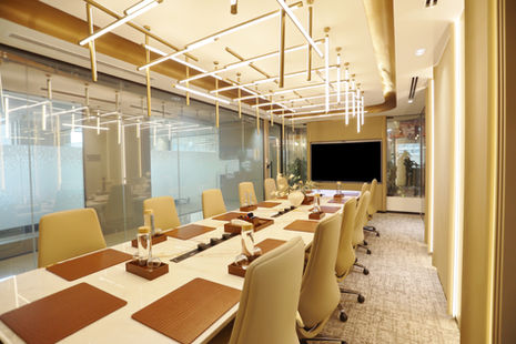 Modern conference room with a long table and beige chairs.