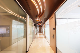 Modern co-working office hallway with glass partitions.
