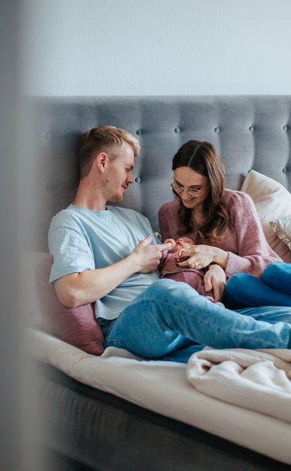 Familie kuschelt im Bett mit Baby - Wochenbettreportage Köln