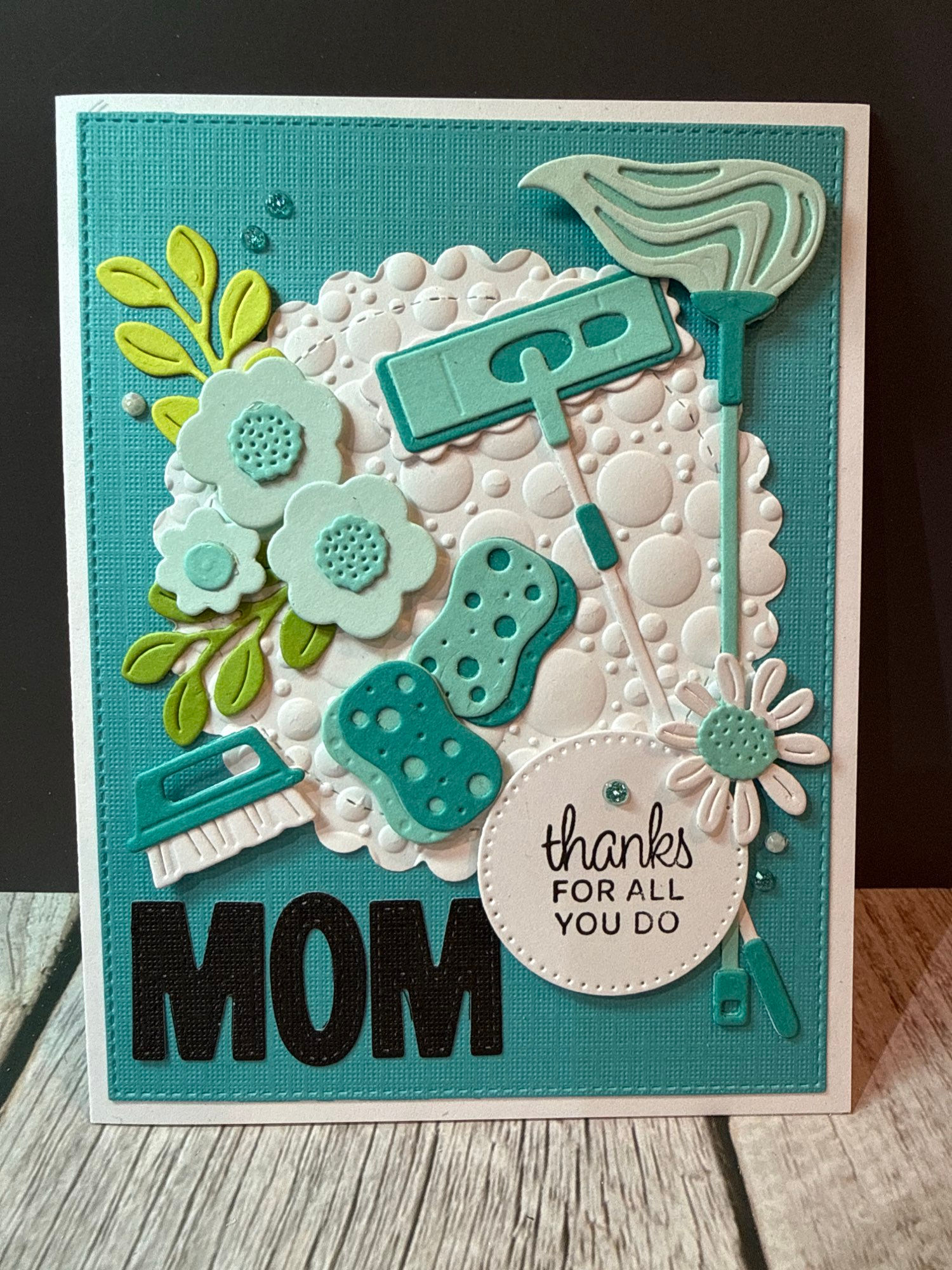 Teal background with cleaning supplies and flowers