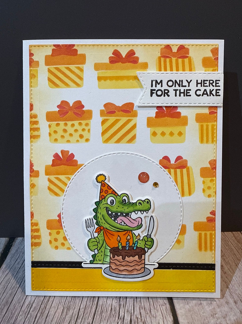 Orange and yellow presents background with crocodile ready to eat cake